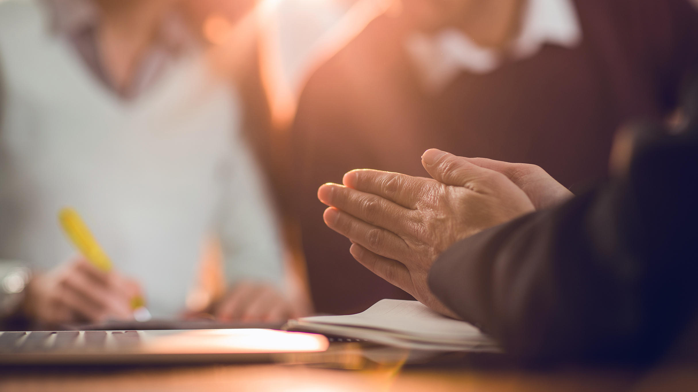 unrecognizable insurance agent rubbing their hands while other party signs a contract