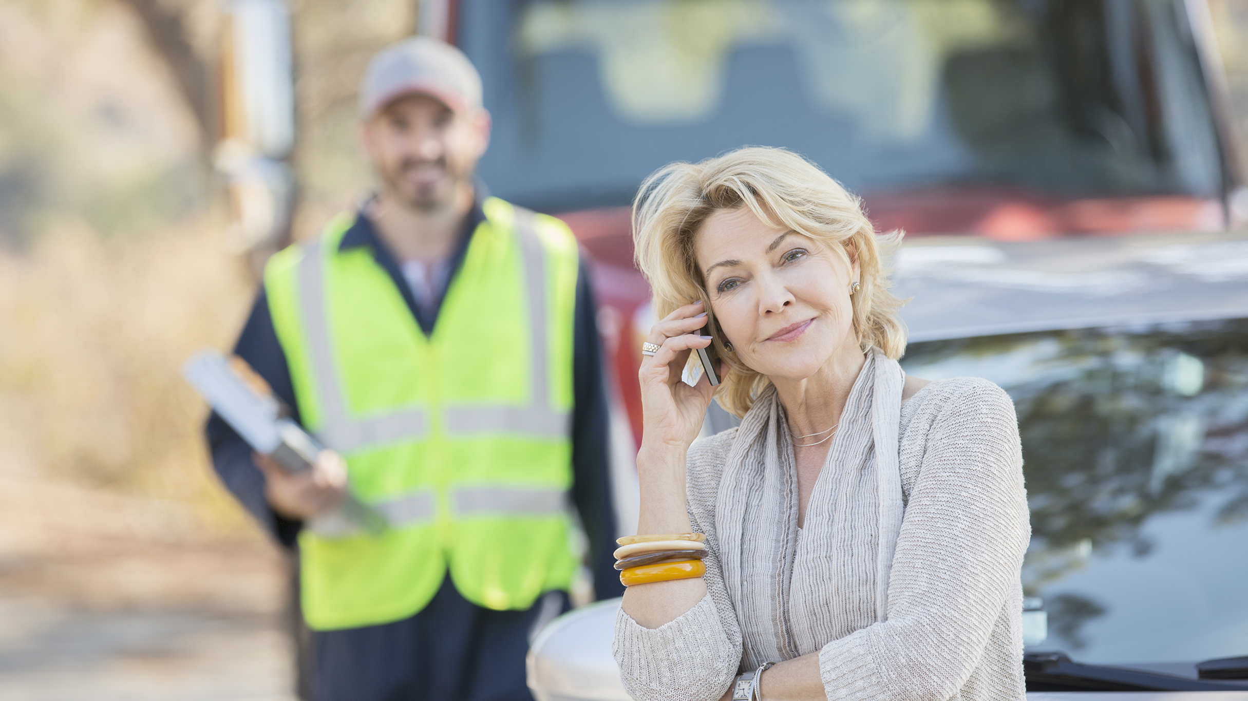 Male tow truck operator loading vehicle on tow truck.