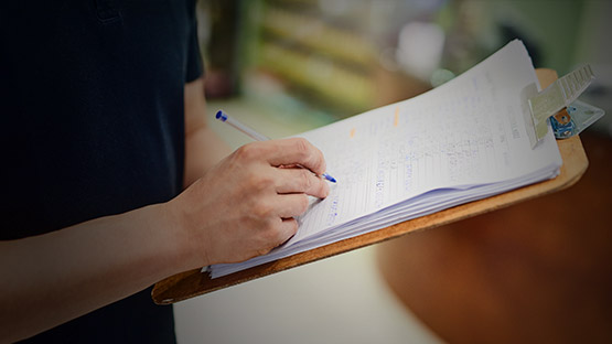 Top rated vendor writing information down on a clip board 
