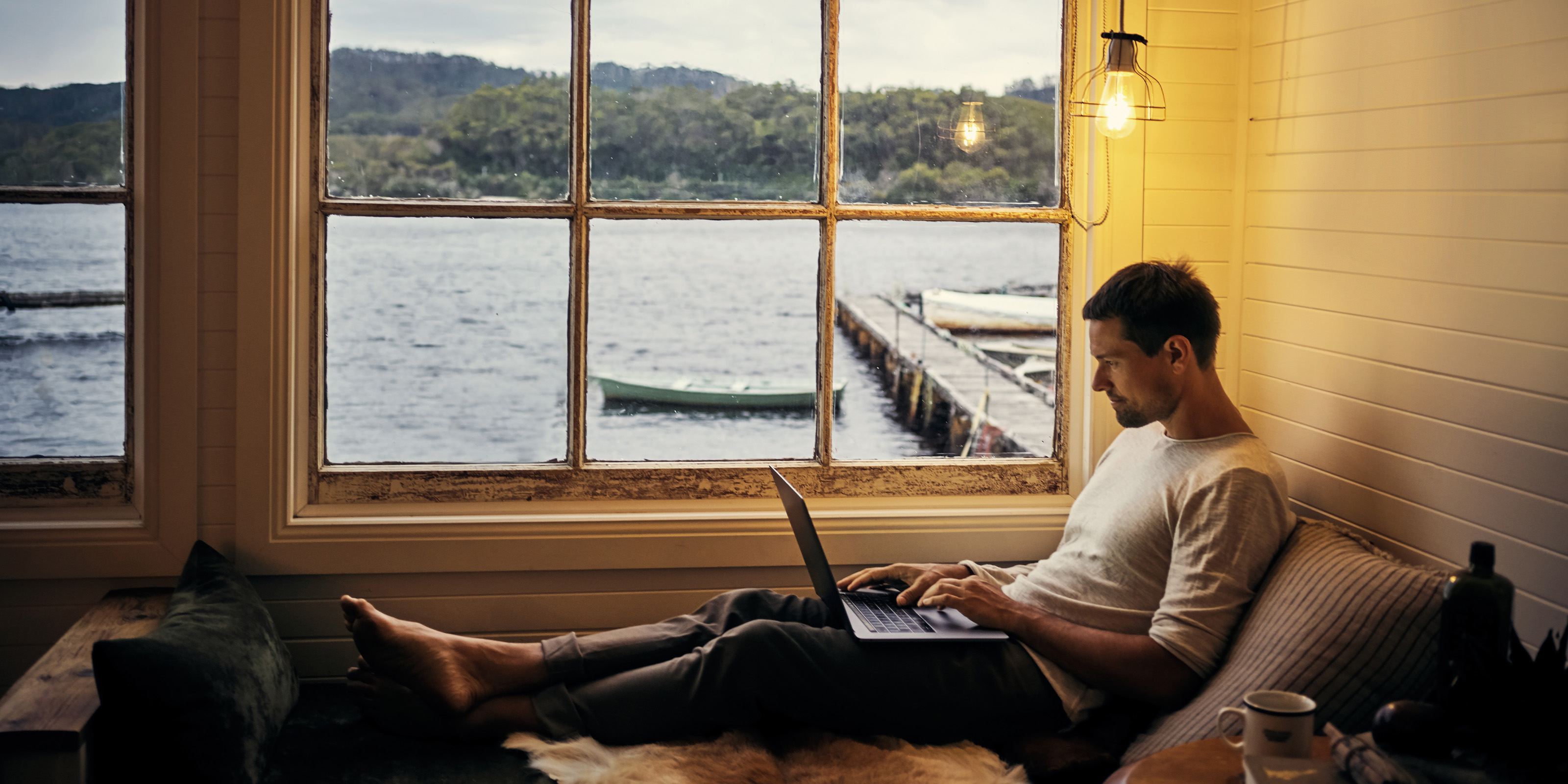 Young man using a laptop while relaxing in his home